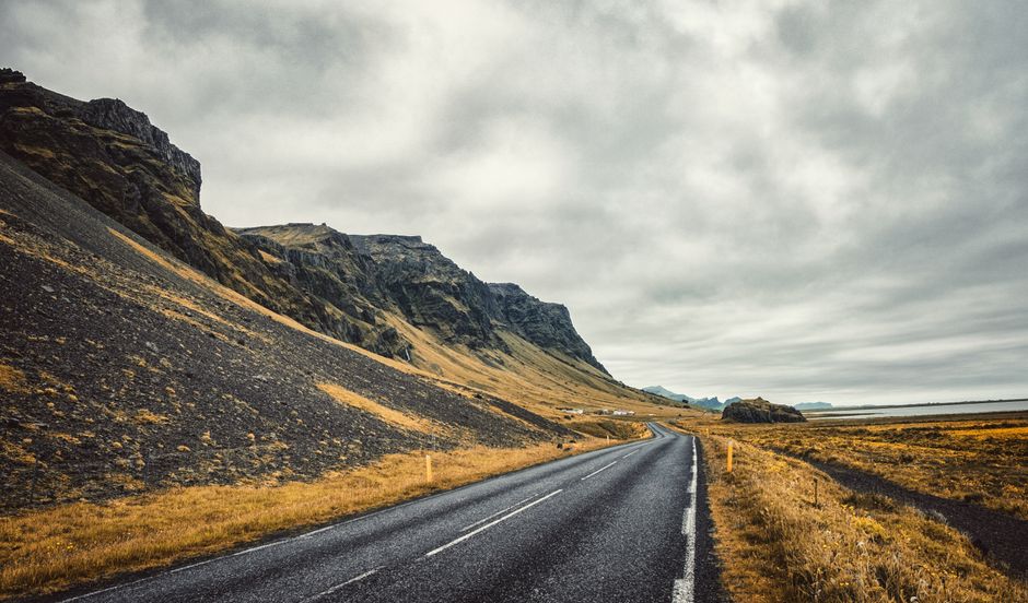 A beautiful stretch of road in Iceland with towering mountains under a cloudy sky, perfect for travel enthusiasts. — Photo de Hugo Guillemard sur Pexels
