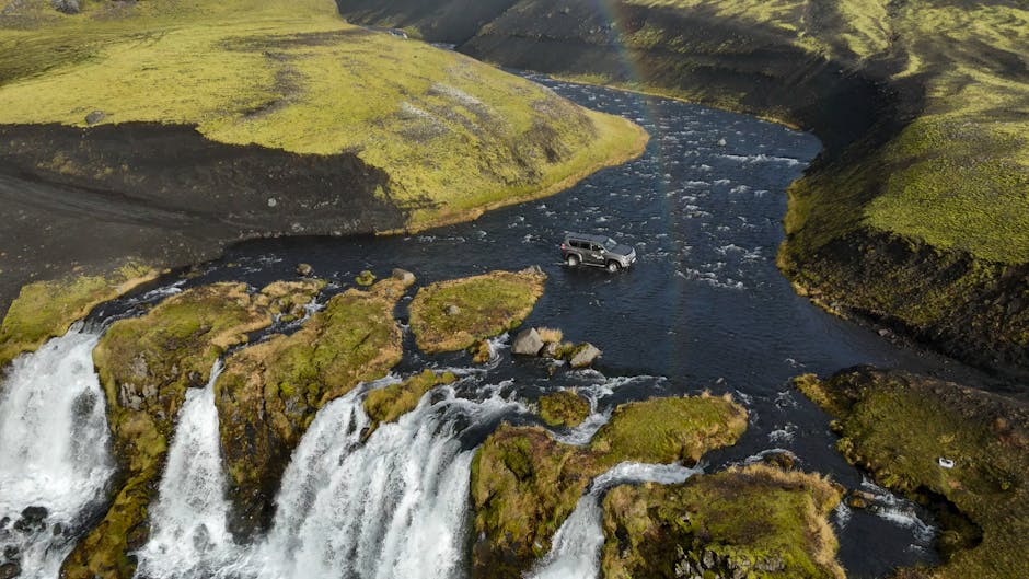 An off-road SUV navigates a river surrounded by lush Icelandic landscapes and waterfalls. — Photo de Veronika Benz sur Pexels